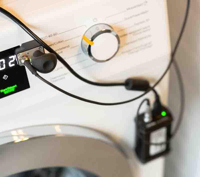 Marc Leyre van Dokter Elektro verricht een diagnostische meting van een wasmachine met laptop en software. Hij is specialist in het herstellen van huishoudtoestellen in Gent en omstreken, Oost- en West-Vlaanderen.