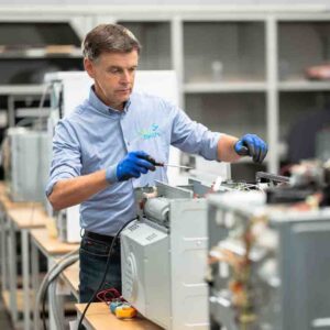 Witgoed herstelling in het herstelcentrum te Mariakerke, Oost-Vlaanderen. Marc Leyre van Dokter Elektro herstelt huishoudtoestellen in regio Gent en omstreken. Hij en zijn collega's Jan en Thomas zijn actief In Oost-en West-Vlaanderen.