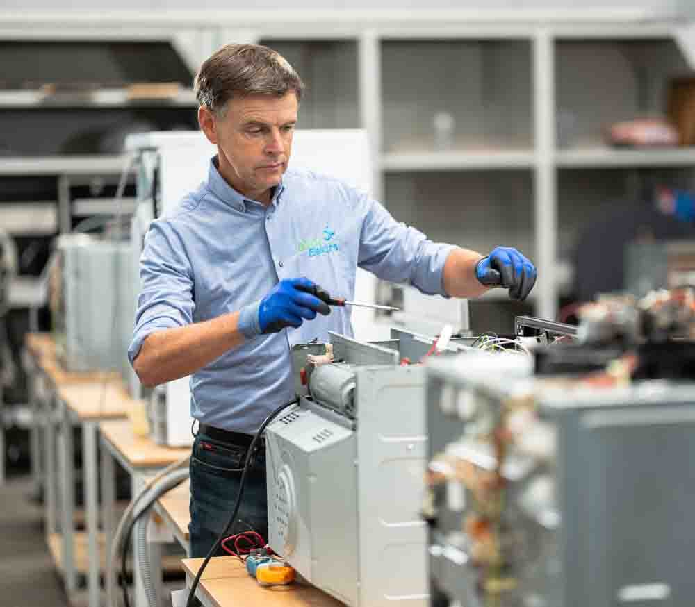 Witgoed herstelling in het repaircentrum te Mariakerke, Oost-Vlaanderen. Marc Leyre van Dokter Elektro herstelt een defecte microgolfoven. Witgoed herstelling Gent en Oost-Vlaanderen.