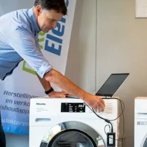 Marc Leyre voert een computerdiagnose uit op een Miele wasmachine. Een vakkundige foutanalyse van moderne huishoudtoestellen in Oost- en West-Vlaanderen.